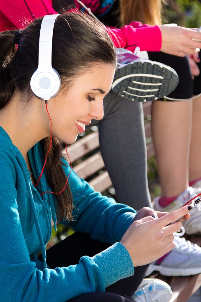 cute girl listening to music with smartphone after exercise